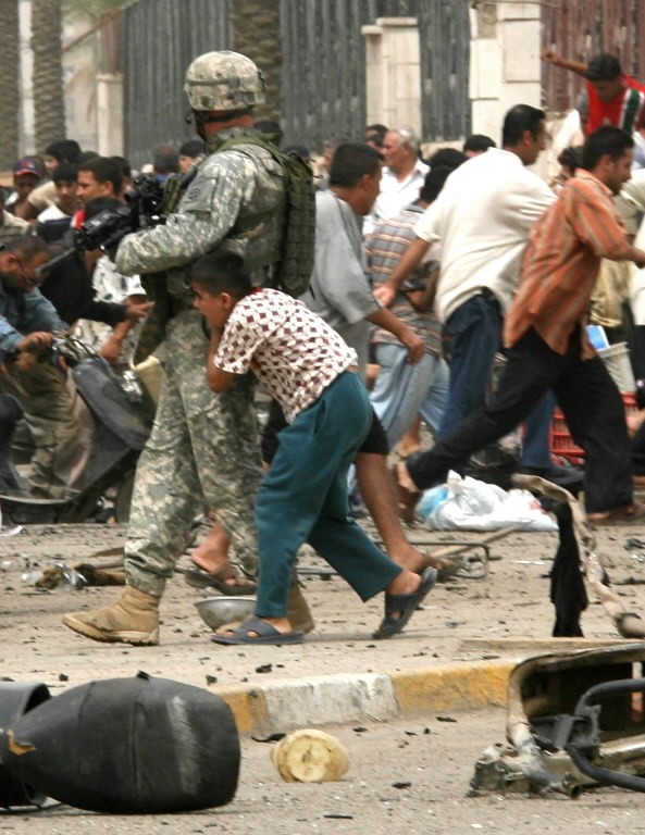 This photo, which appeared on the front page of this morning's edition of The New York Times, shows an Iraqi boy taking cover behind a U.S. soldier as civilians fled the sound of gunshots following a suicide bombing yesterday in central Baghdad that killed at least 21 people and wounded 66 others.